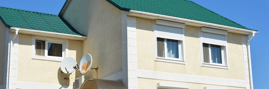 House with green roof and rolling shutters in Tucson, AZ.