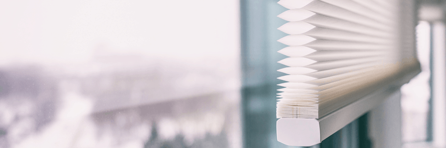 White indoor window blinds in soft light.
