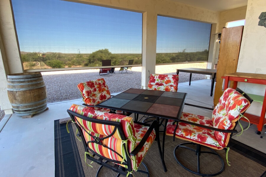 Patio with floral chairs and mesh window shades in Tucson, AZ.