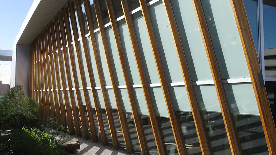 Modern building with angled wooden slats and glass facade.