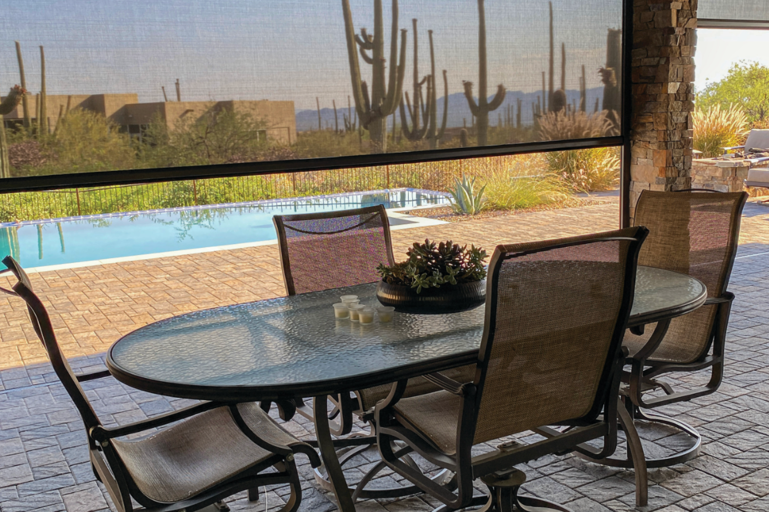 Patio with solar screen, table, chairs, and desert view.