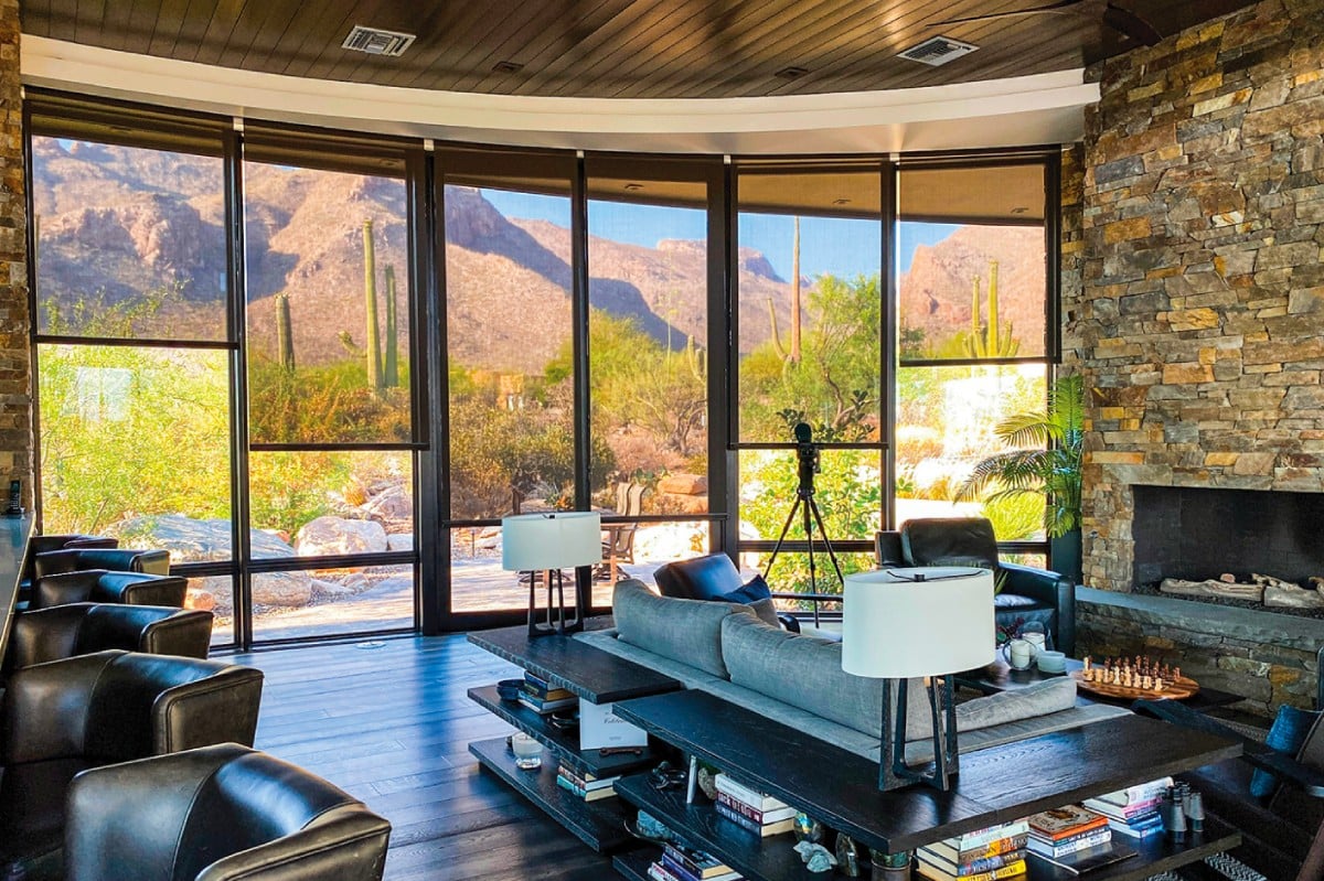 Living room with solar screens on panoramic windows, mountain view.