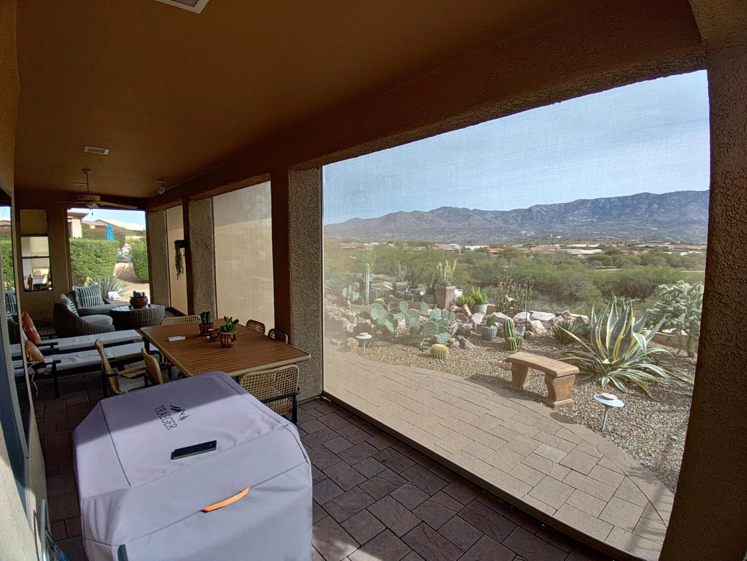 View from inside patio through solar screen with desert mountain landscape in background