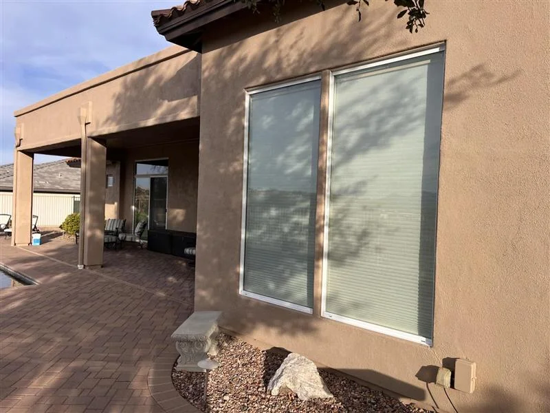 Solar screen installed on exterior window of stucco home