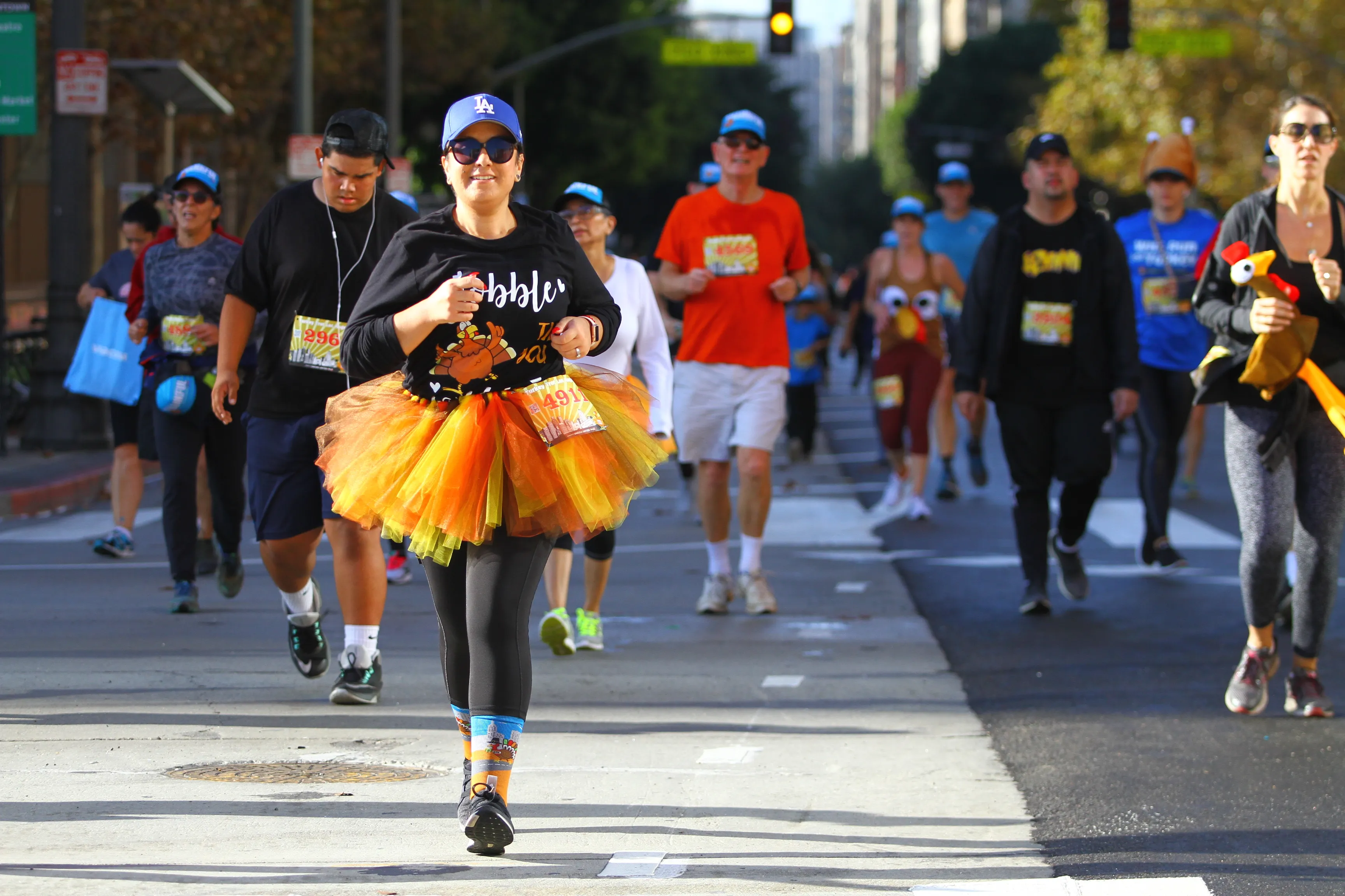 People participating in a themed race wearing colorful costumes and running on a city street.