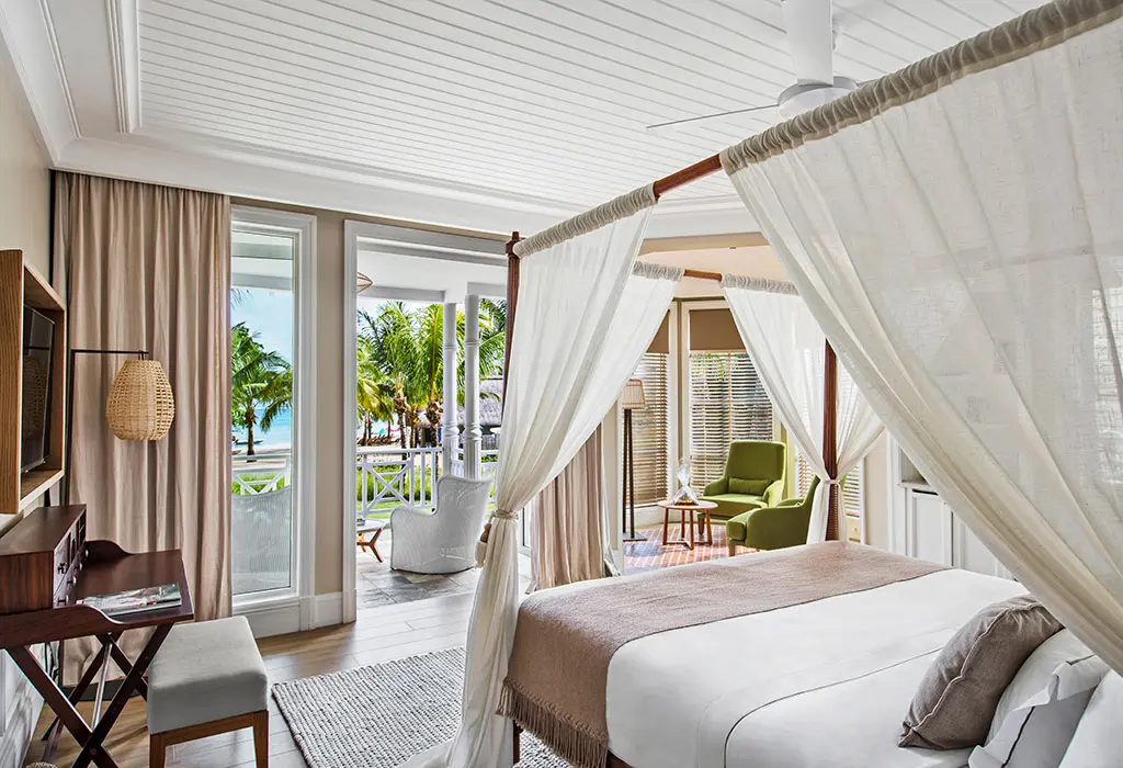 Canopy bed in a sunlit room with large windows and soft textures—Island Lilly’s intimate guest haven for rest and renewal for ultimate wellness in tropical island
