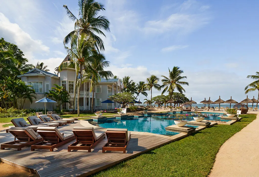 Tropical swimming pool surrounded by palm trees and lounge chairs—Island Lilly’s tranquil outdoor escape in Mauritius