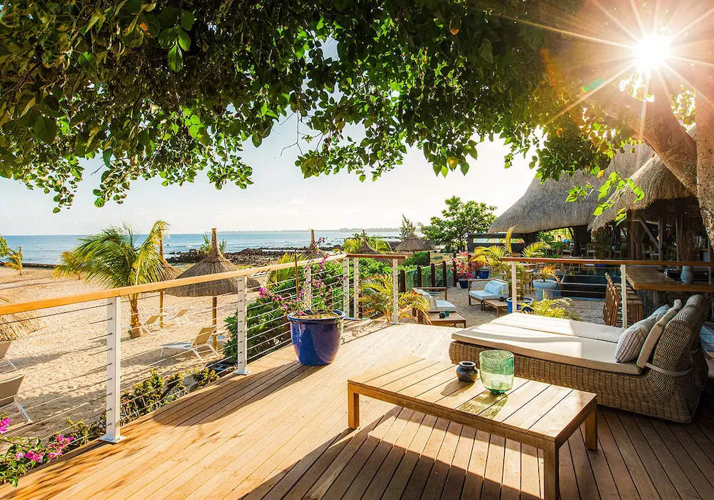 Open-air dining pavilion with thatched roof beside a pool and ocean view in Mauritius—Island Lilly’s tranquil setting for relaxed meals and coastal indulgence