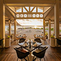 Serene hotel patio overlooking the ocean, with gentle waves and coastal breeze setting the scene for peaceful reflection and connection.
