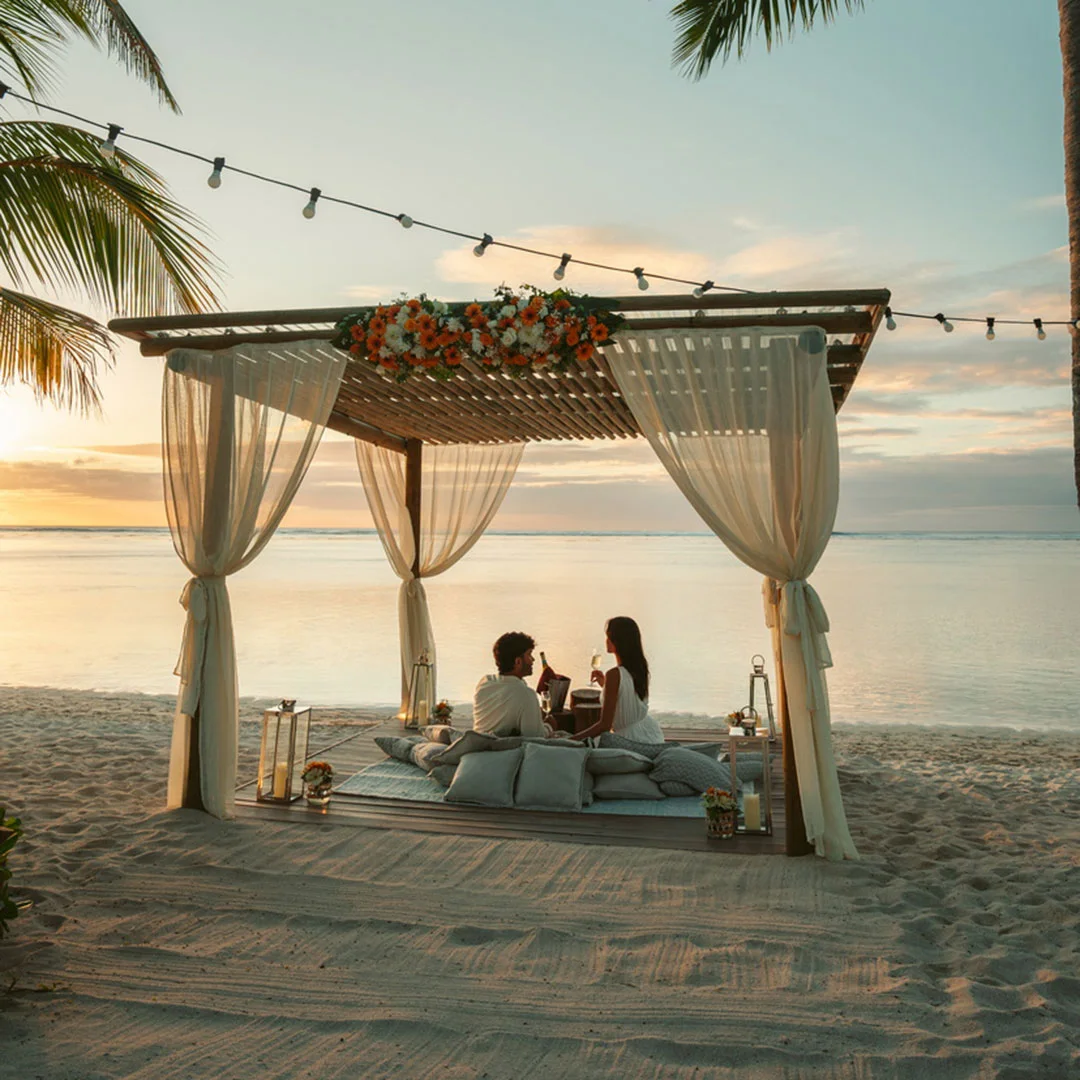 Boats floating near lush green hills and thatched-roof resort in Mauritius—Island Lilly’s curated leisure and exploration experiences