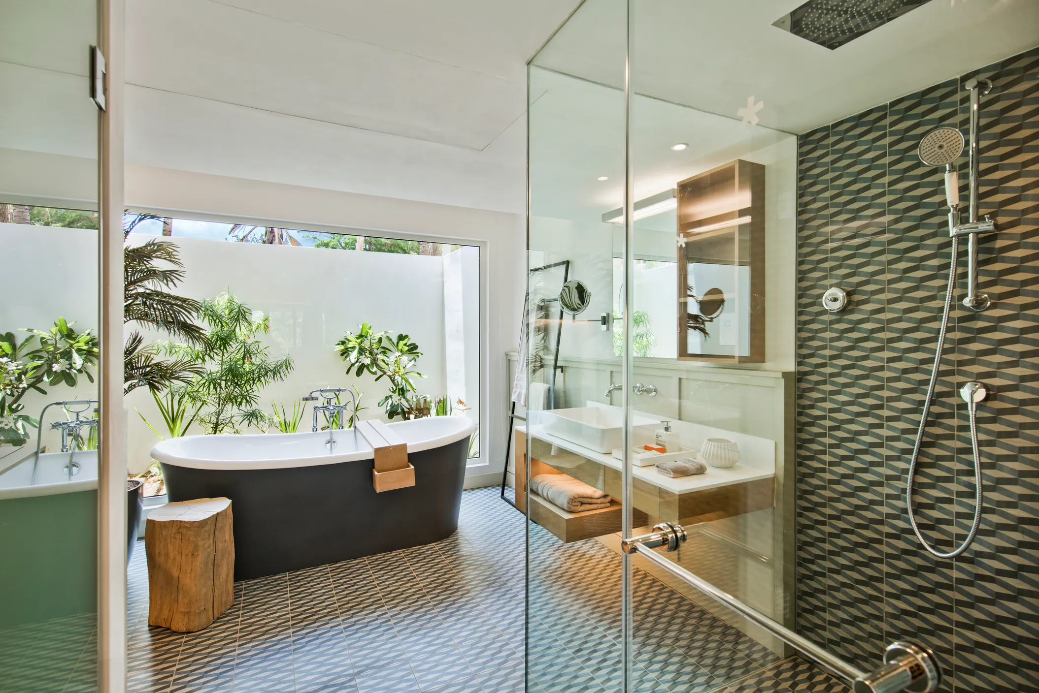 Hotel suite with a wooden floor and green armchair, opening onto a balcony above the sea