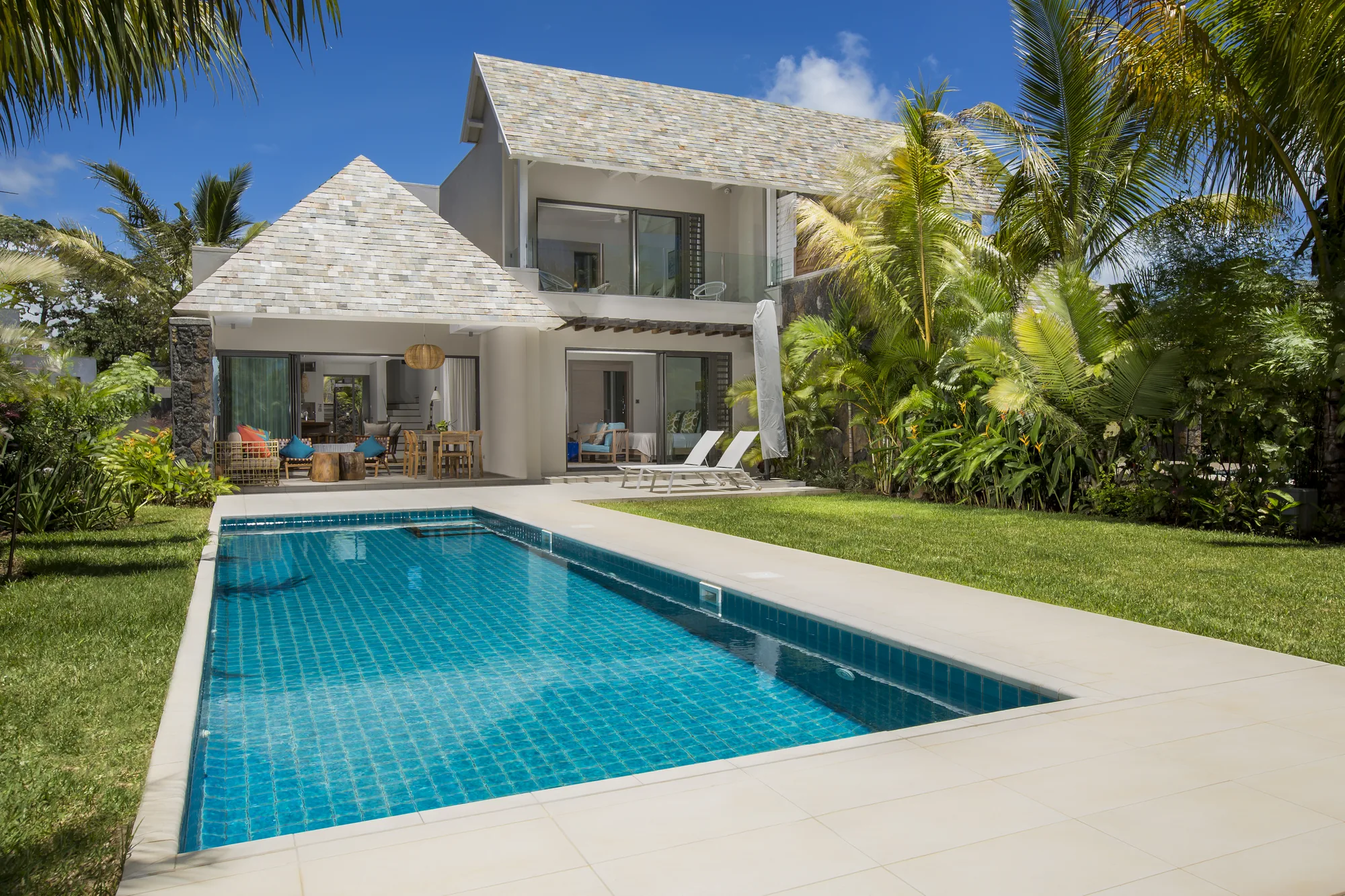A two-storey villa with a private pool and a lawn