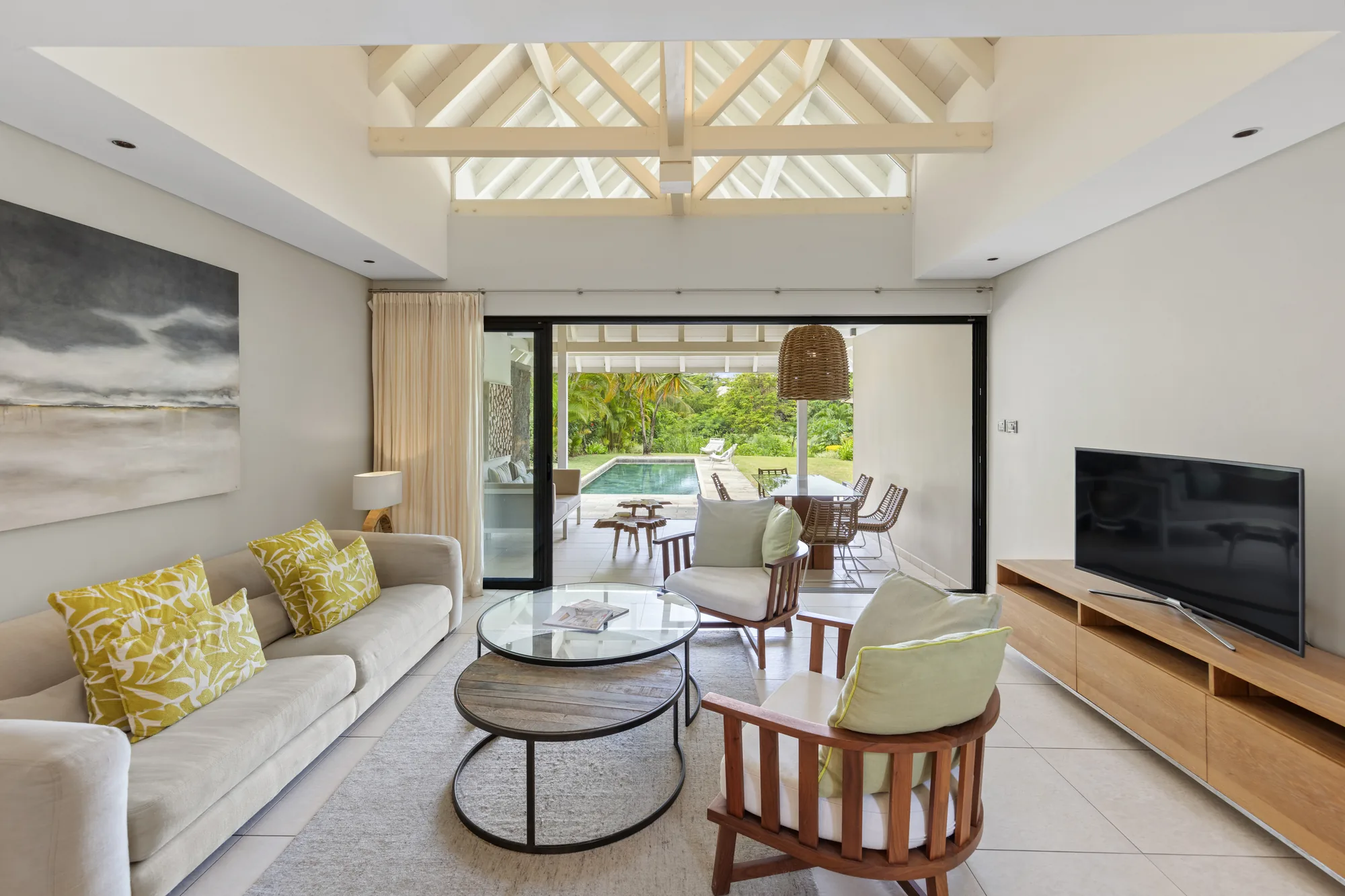 A living room with sofas opening onto a private pool terrace