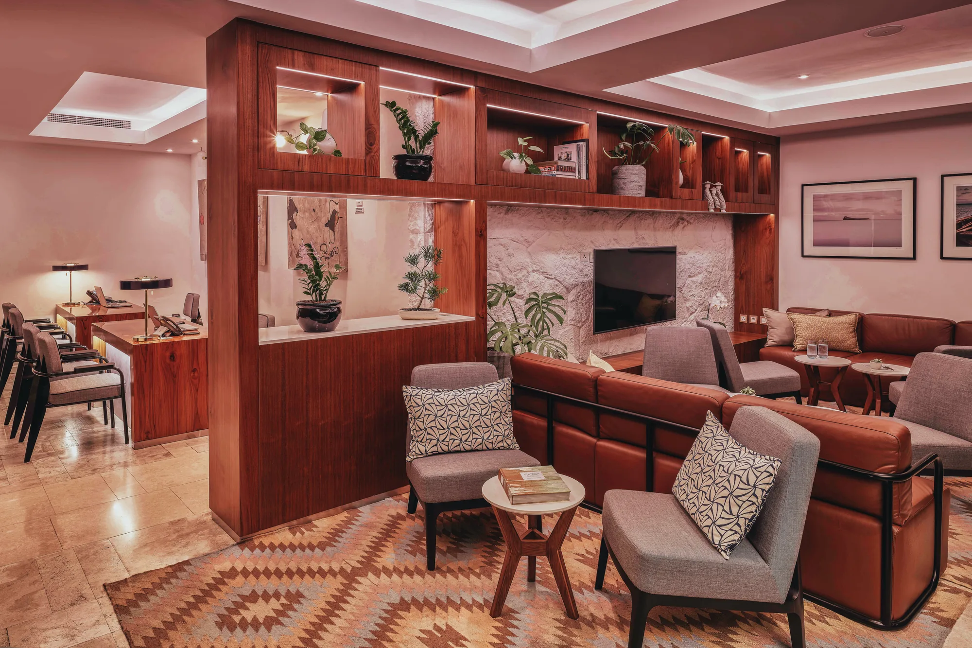 A lounge with leather sofas, timber shelving and patterned rugs