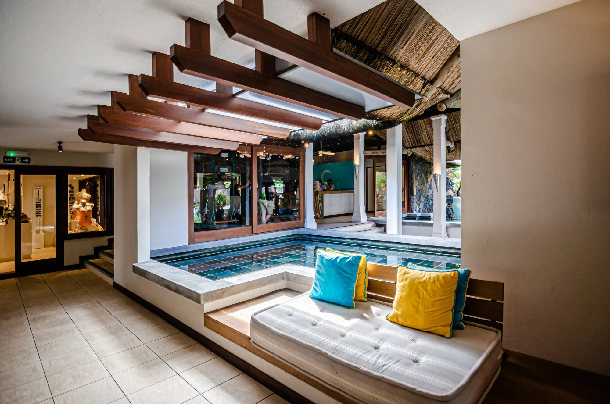A sunken seating area with cushions under a timber ceiling