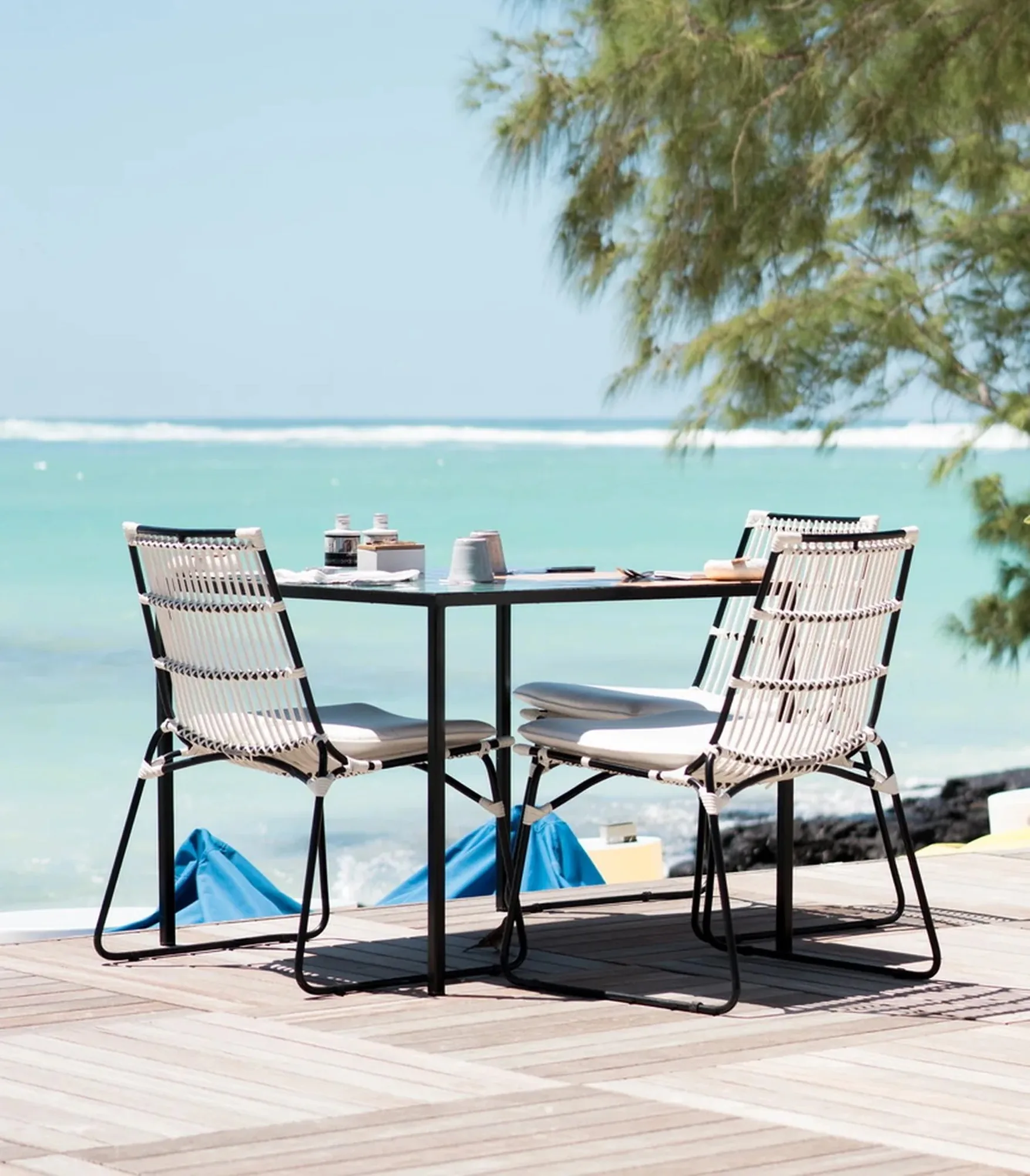 A table and two chairs on a deck beside the lagoon