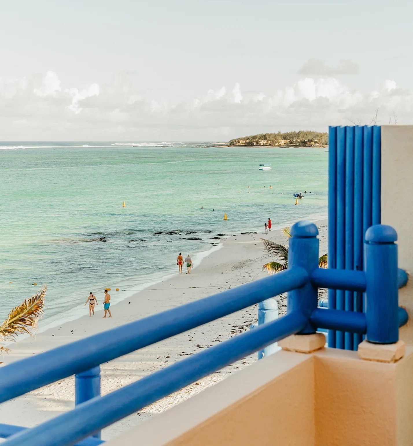 A blue balcony railing overlooking the beach and lagoon