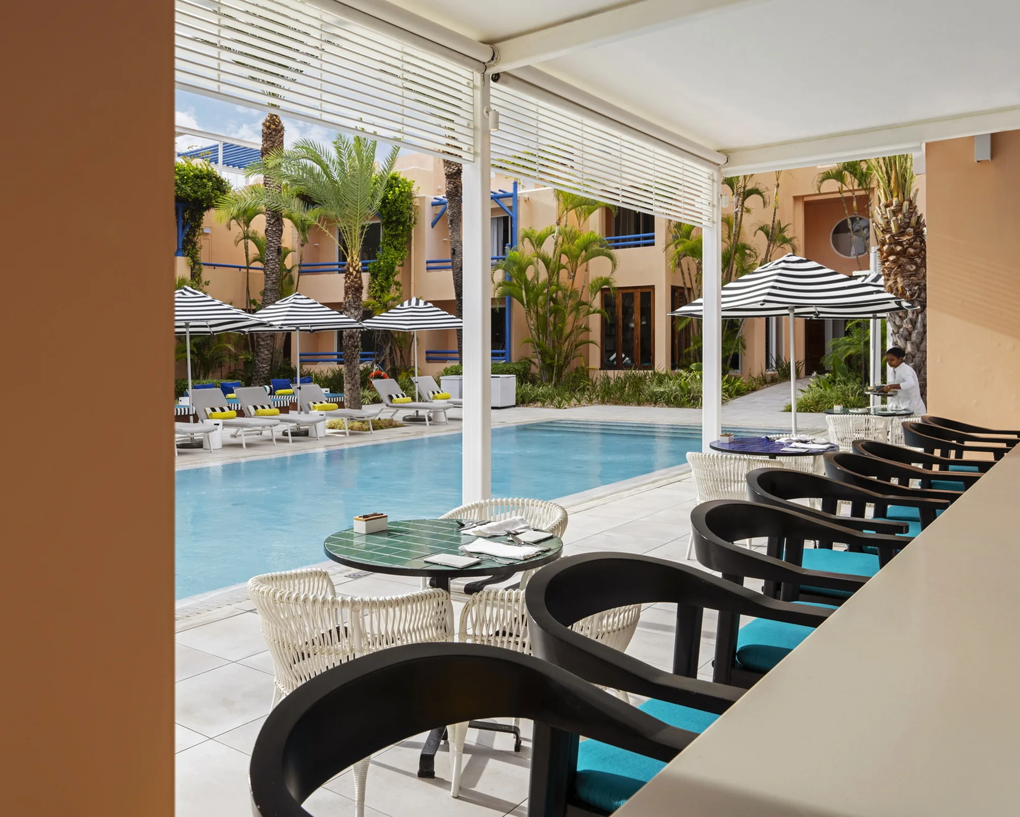 Black chairs along a counter looking over the pool and courtyard