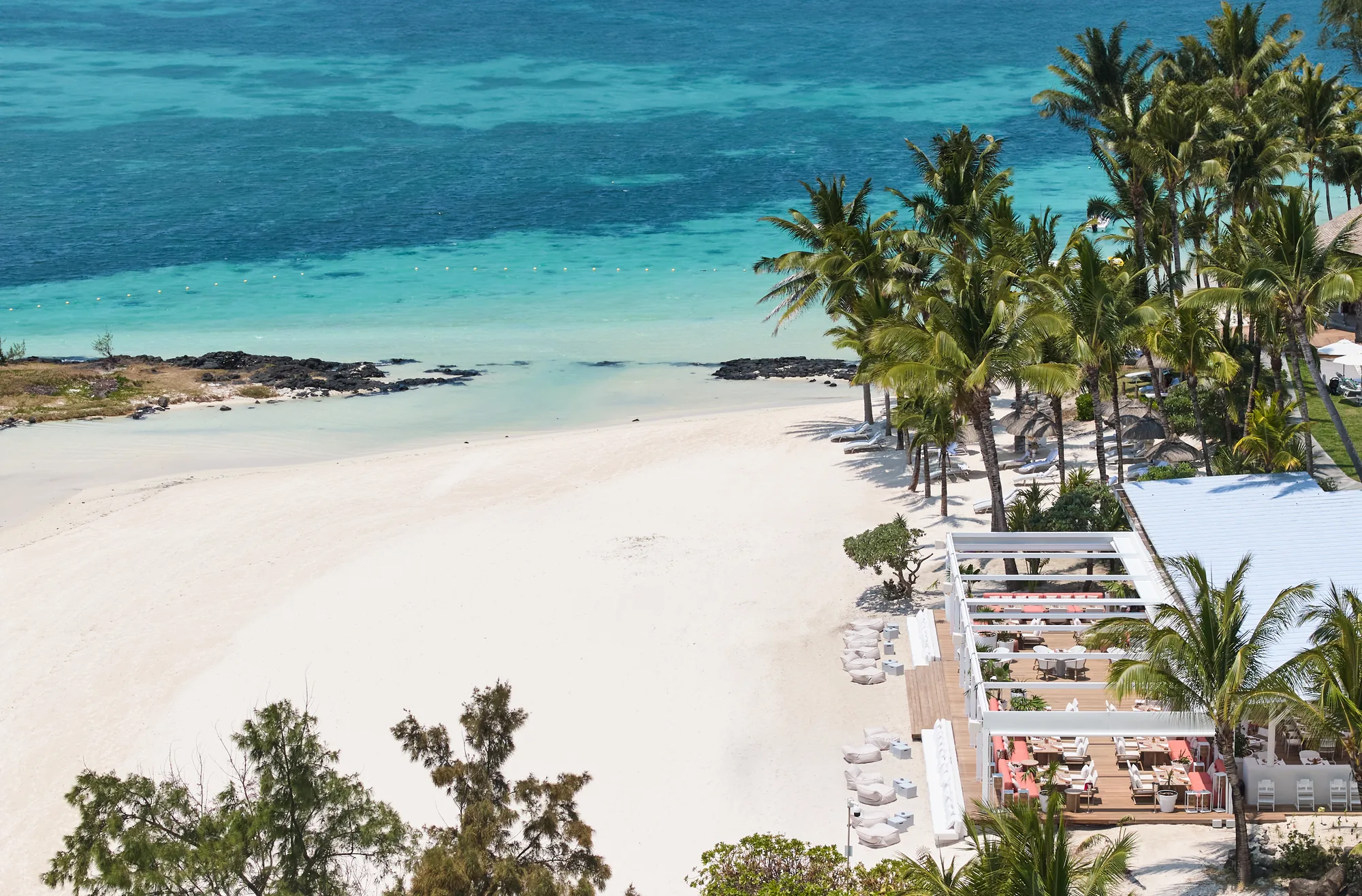 Aerial view of the white beach and turquoise lagoon beside a beach restaurant