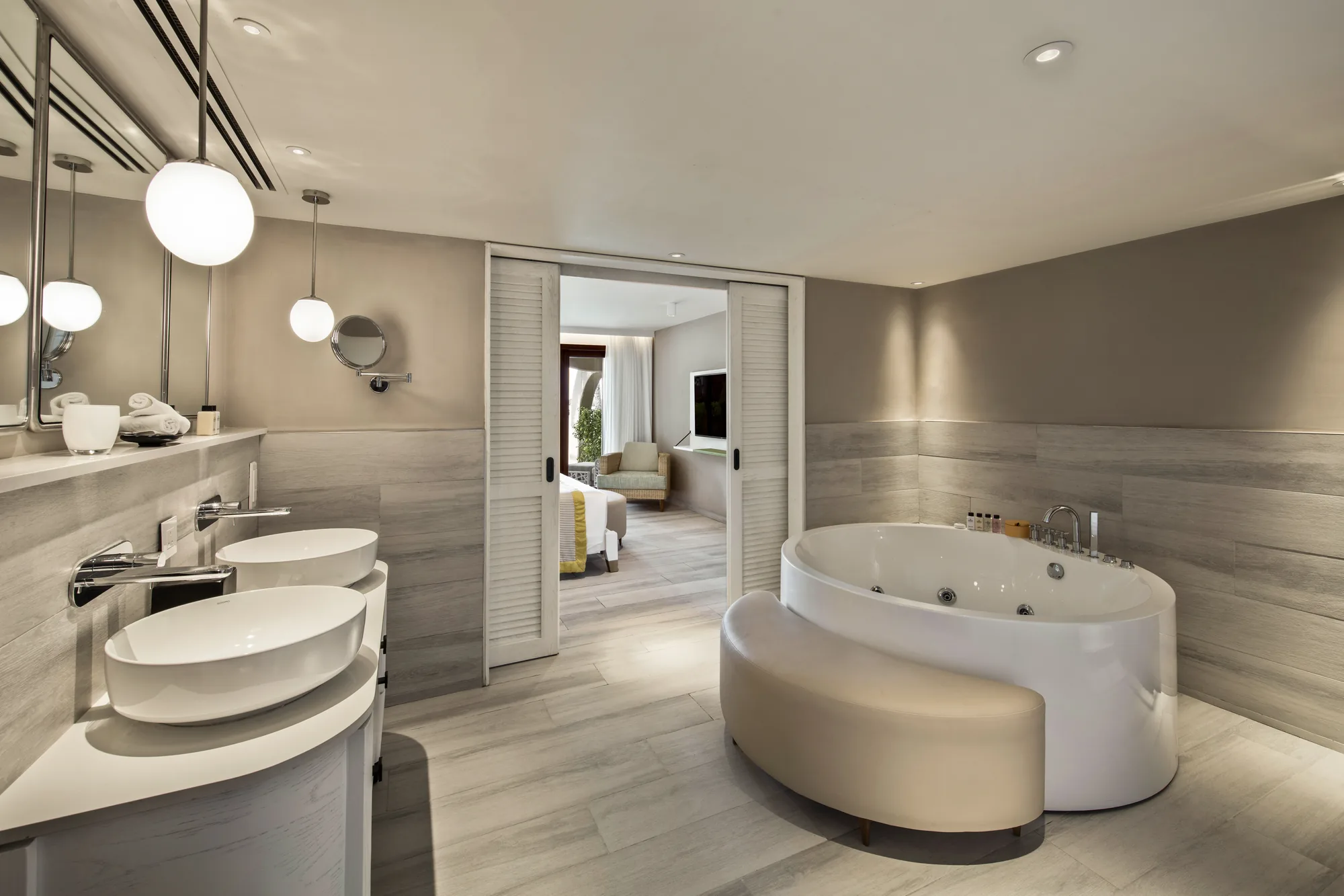 A bathroom with two vessel basins and a whirlpool bath