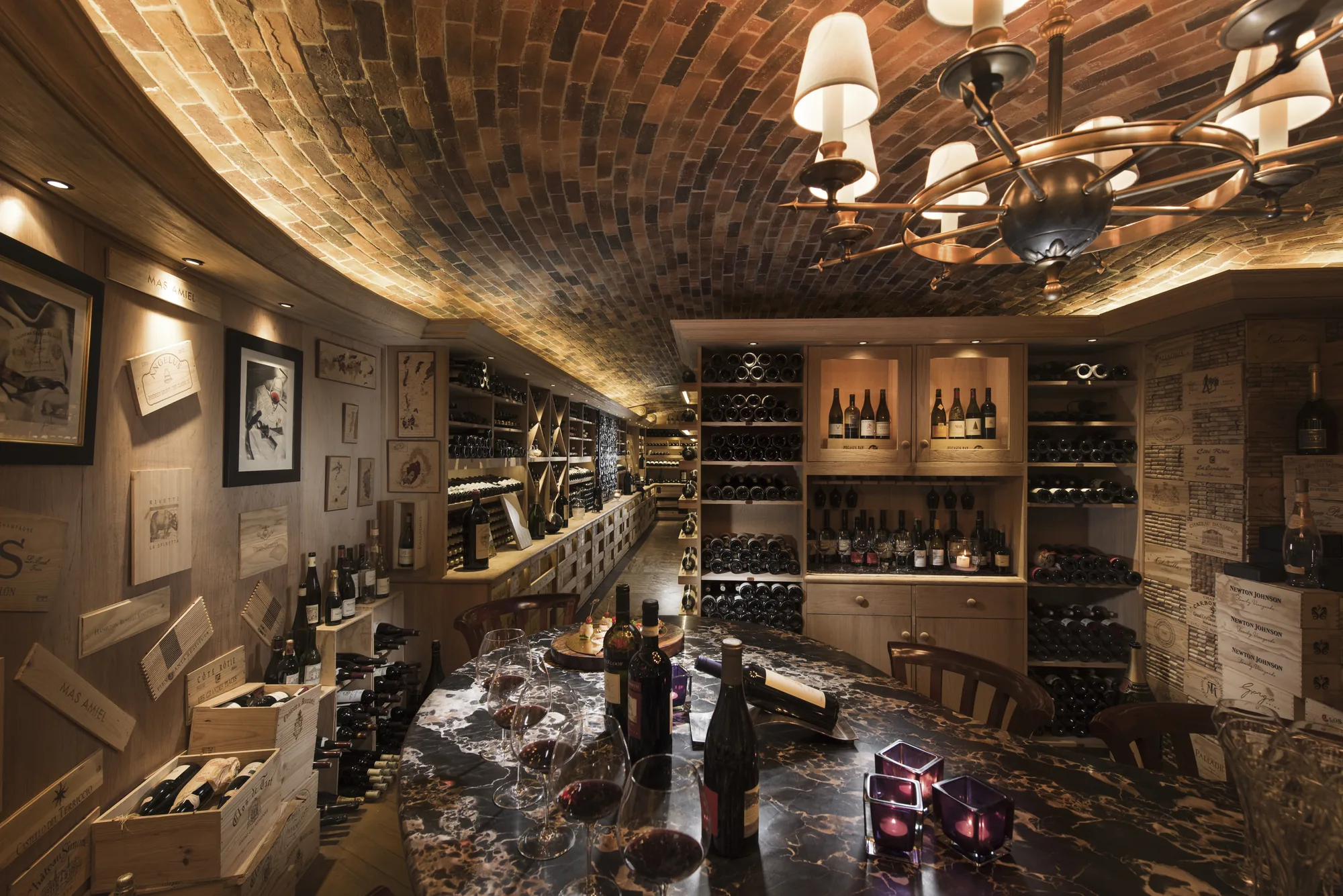 A wine cellar with a barrel-vaulted brick ceiling and shelves of bottles