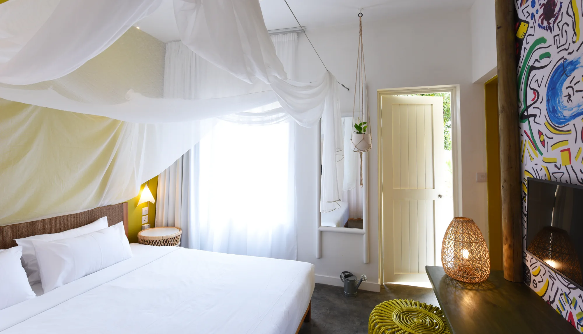 A bedroom with a white canopy over the bed and a painted wall