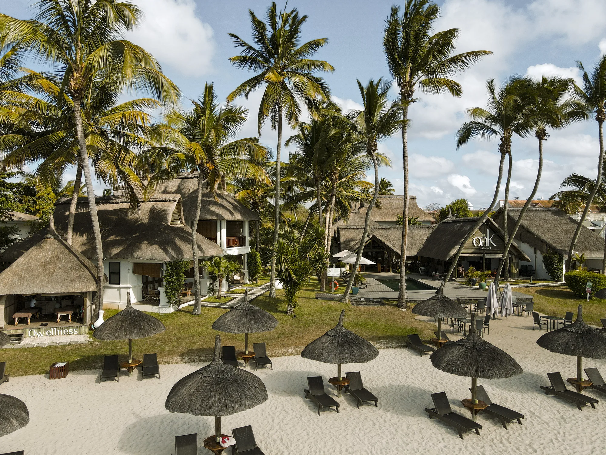 Constance Sakoa Boutik, its thatched buildings behind a beach of thatched parasols and loungers