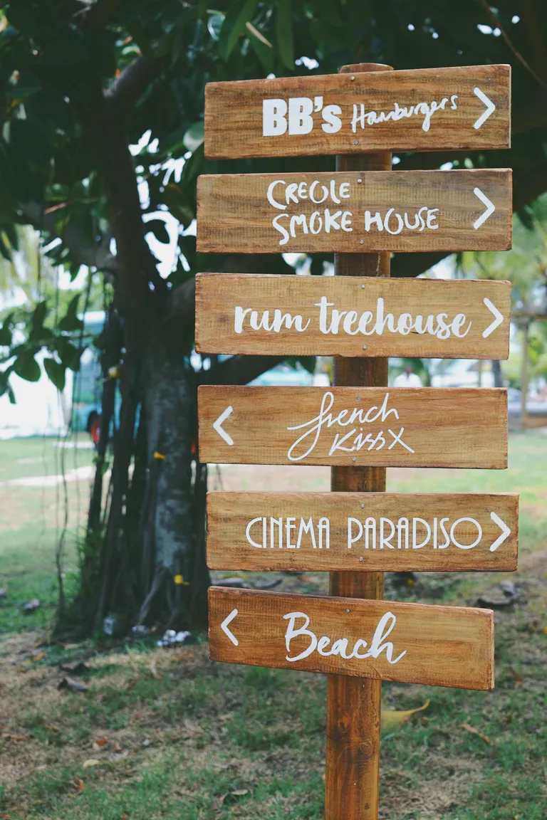 A wooden signpost pointing to the restaurants, the cinema and the beach