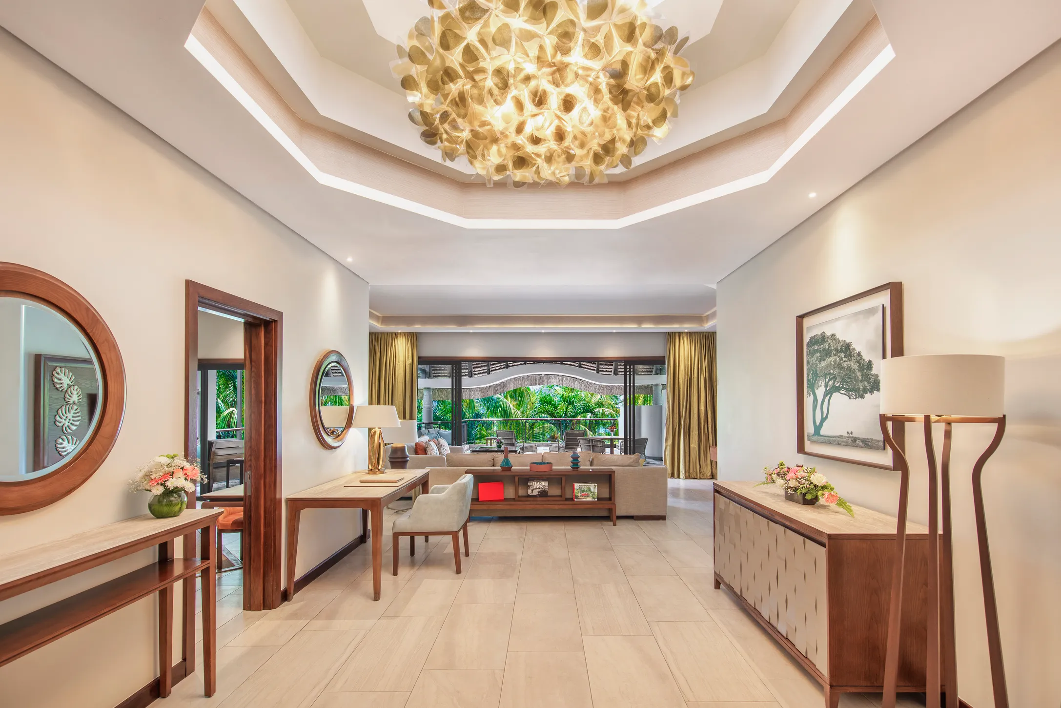 A suite living room with a sculptural ceiling light and doors opening to the garden