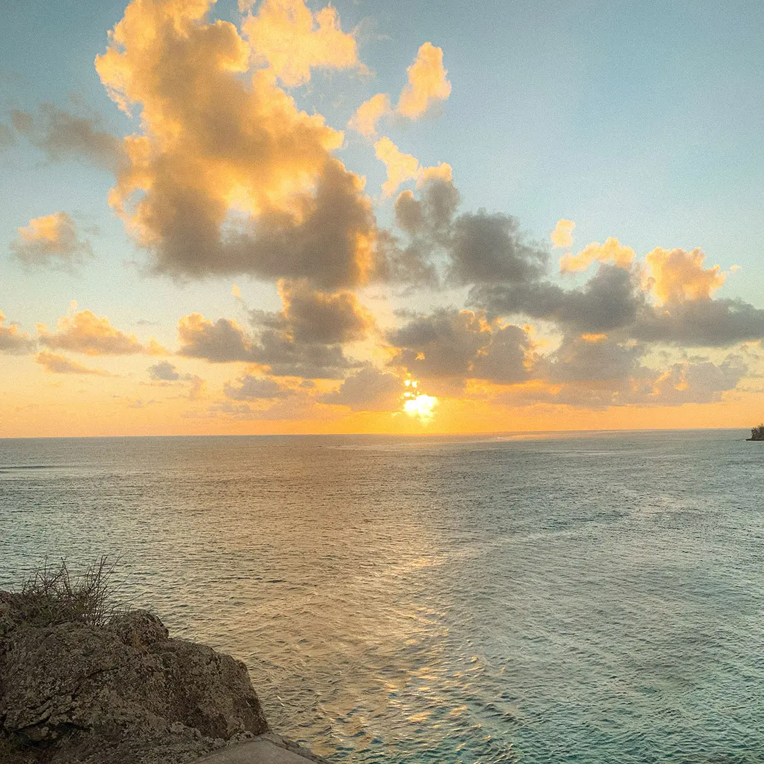 Sunset over the sea from a rocky shore