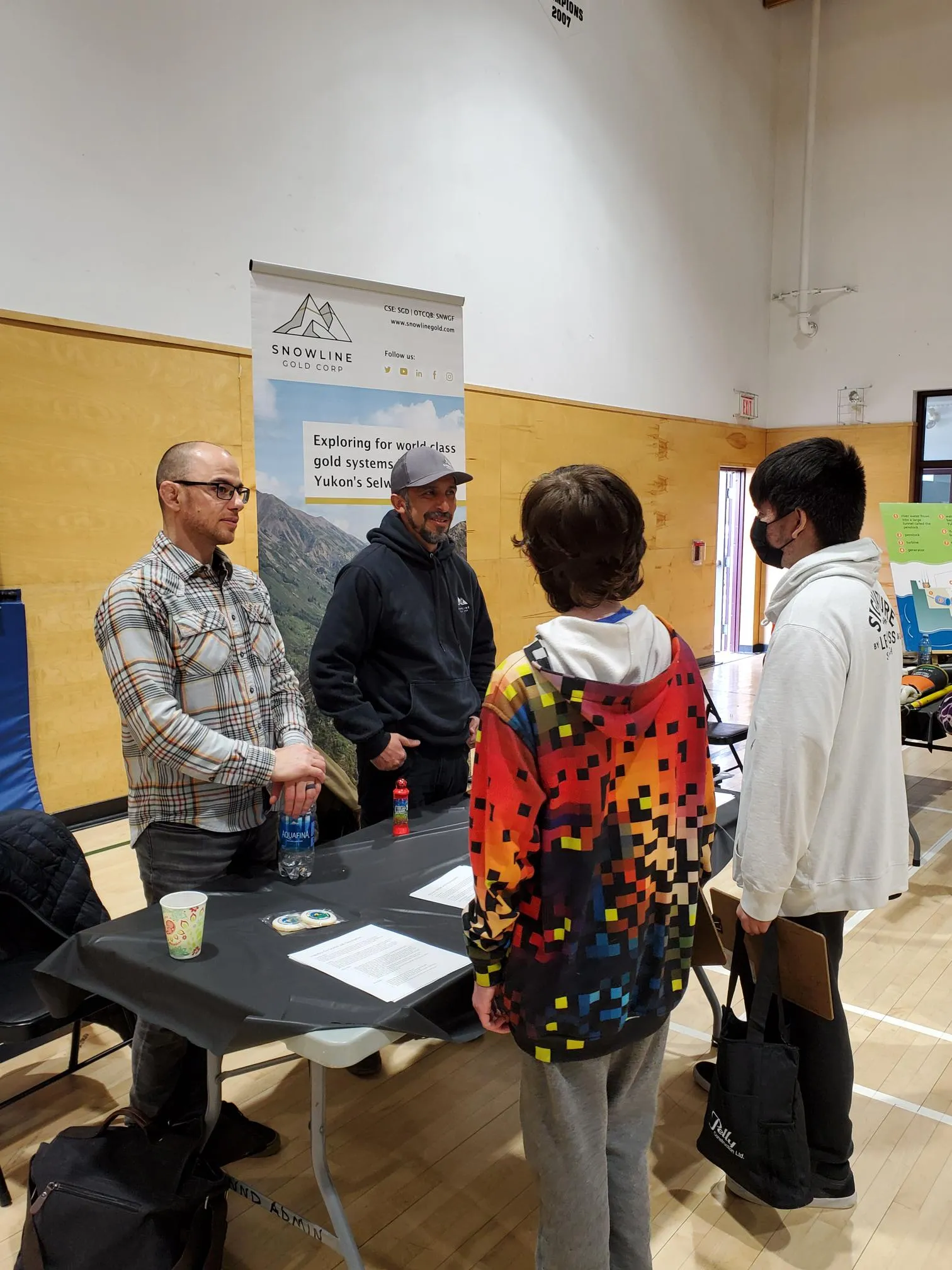 4 people talking in a booth roll up event for mining