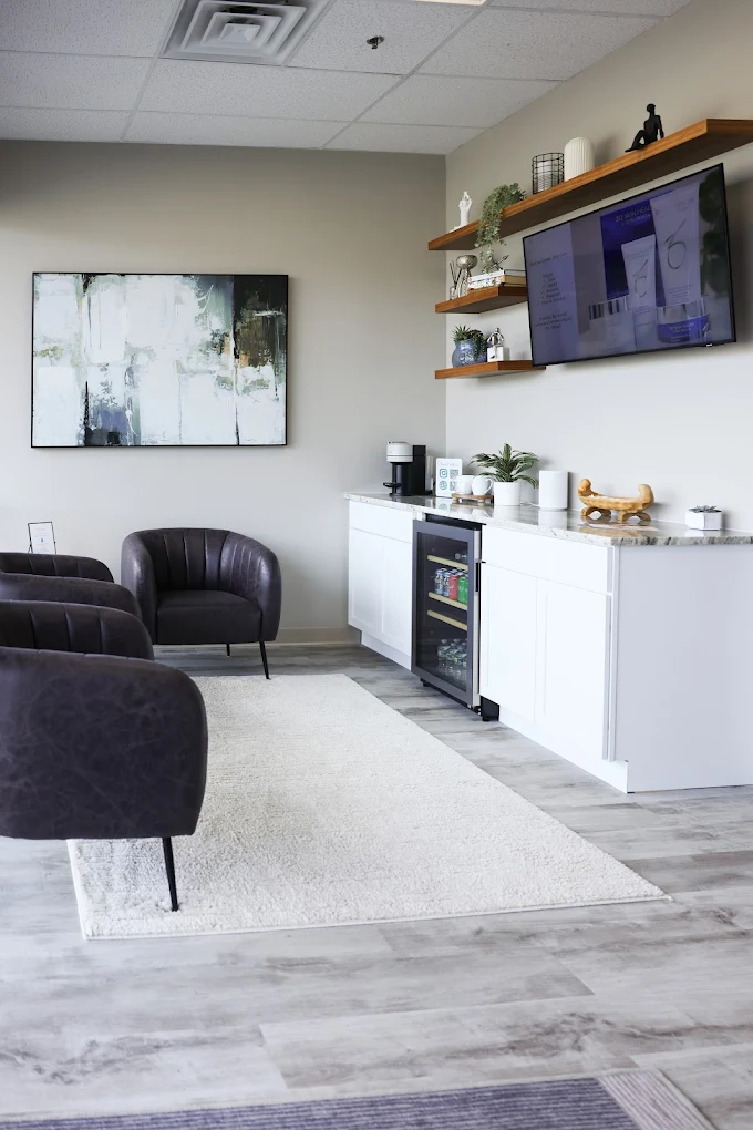 Minimalist waiting area with beverage station and lounge chairs