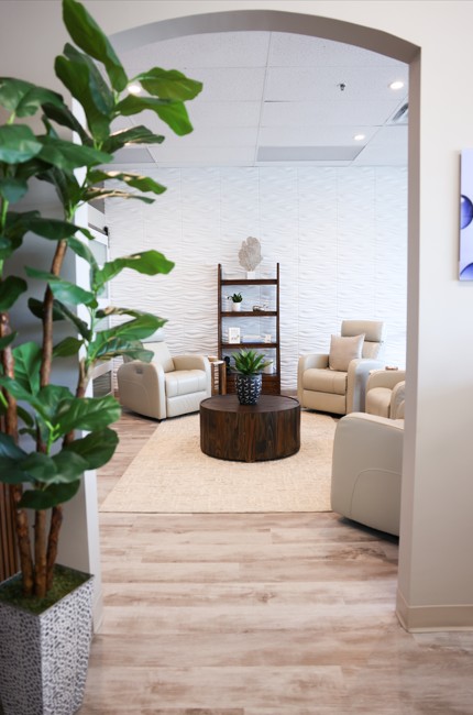 Confident woman seated in natural light at ThrIVwell, representing luxury wellness and  personalized aesthetic care in Saugus, MA.