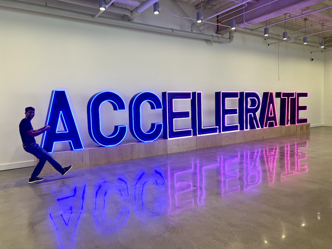 Our team posing in front of the Accelerate signage