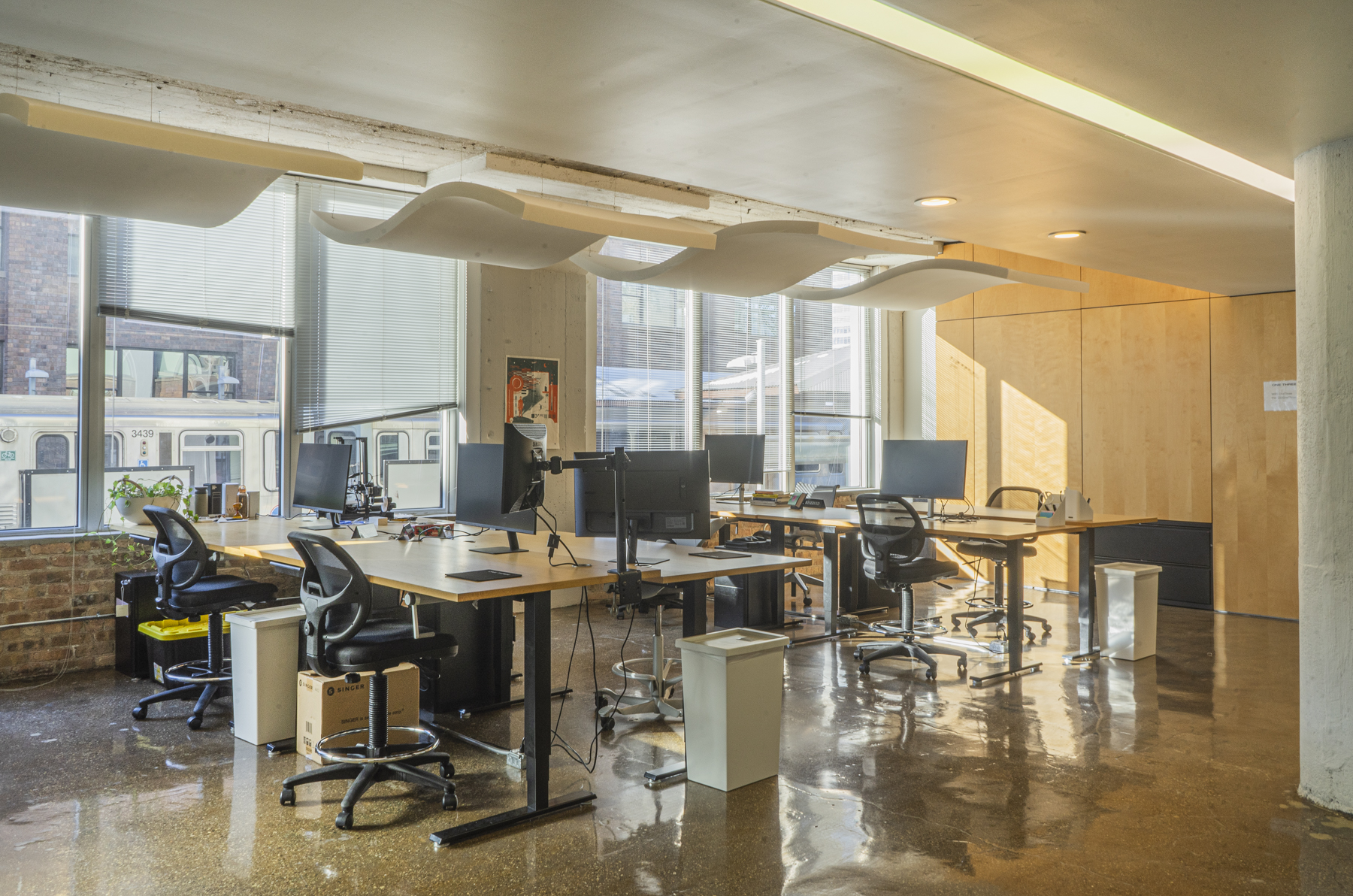 Coworking desks on the third floor equipped with monitors and ergonomic seating