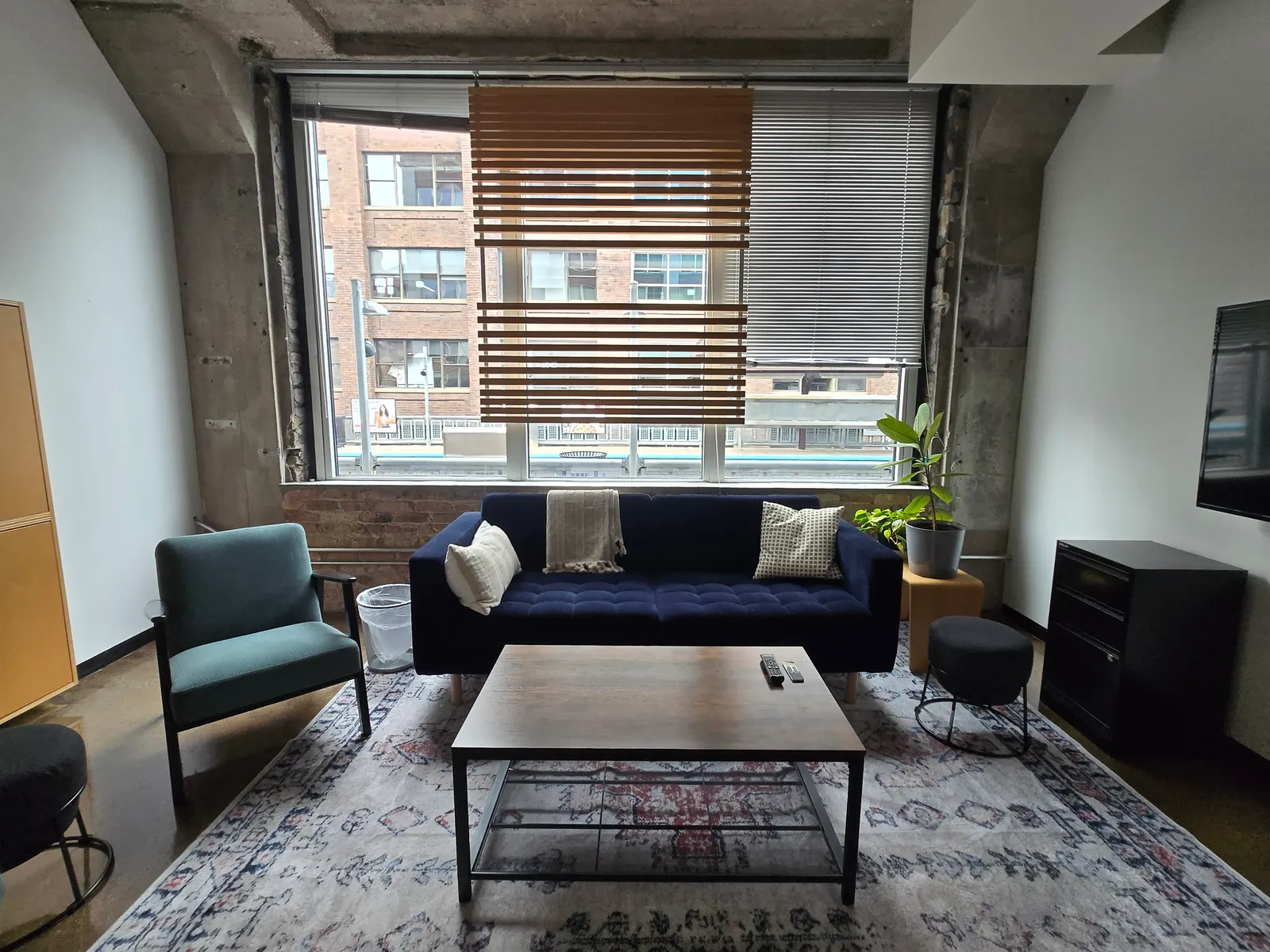 3:5 Collaboration Room at Two Thirty with a blue couch facing a coffee table and a large window