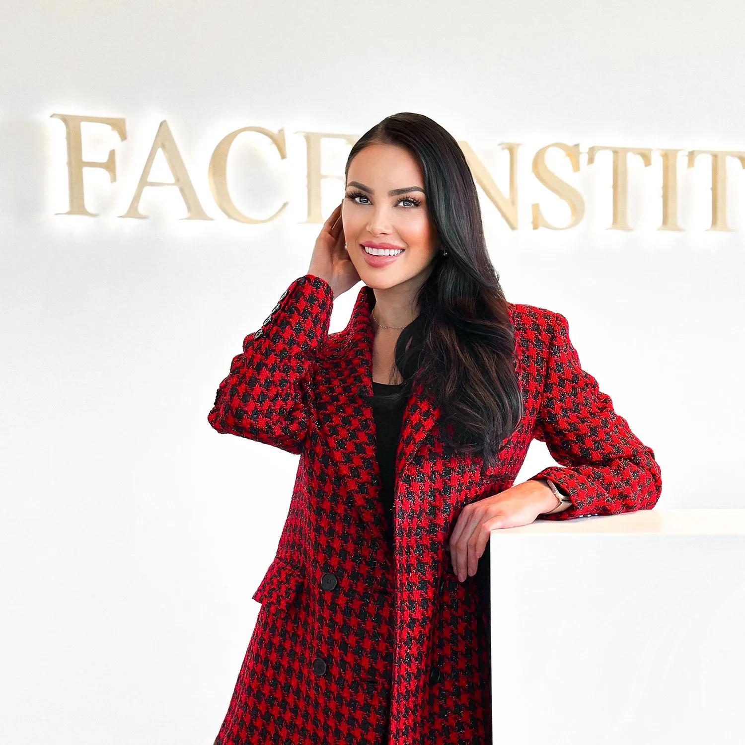 A woman in a red and black coat posing for a picture.