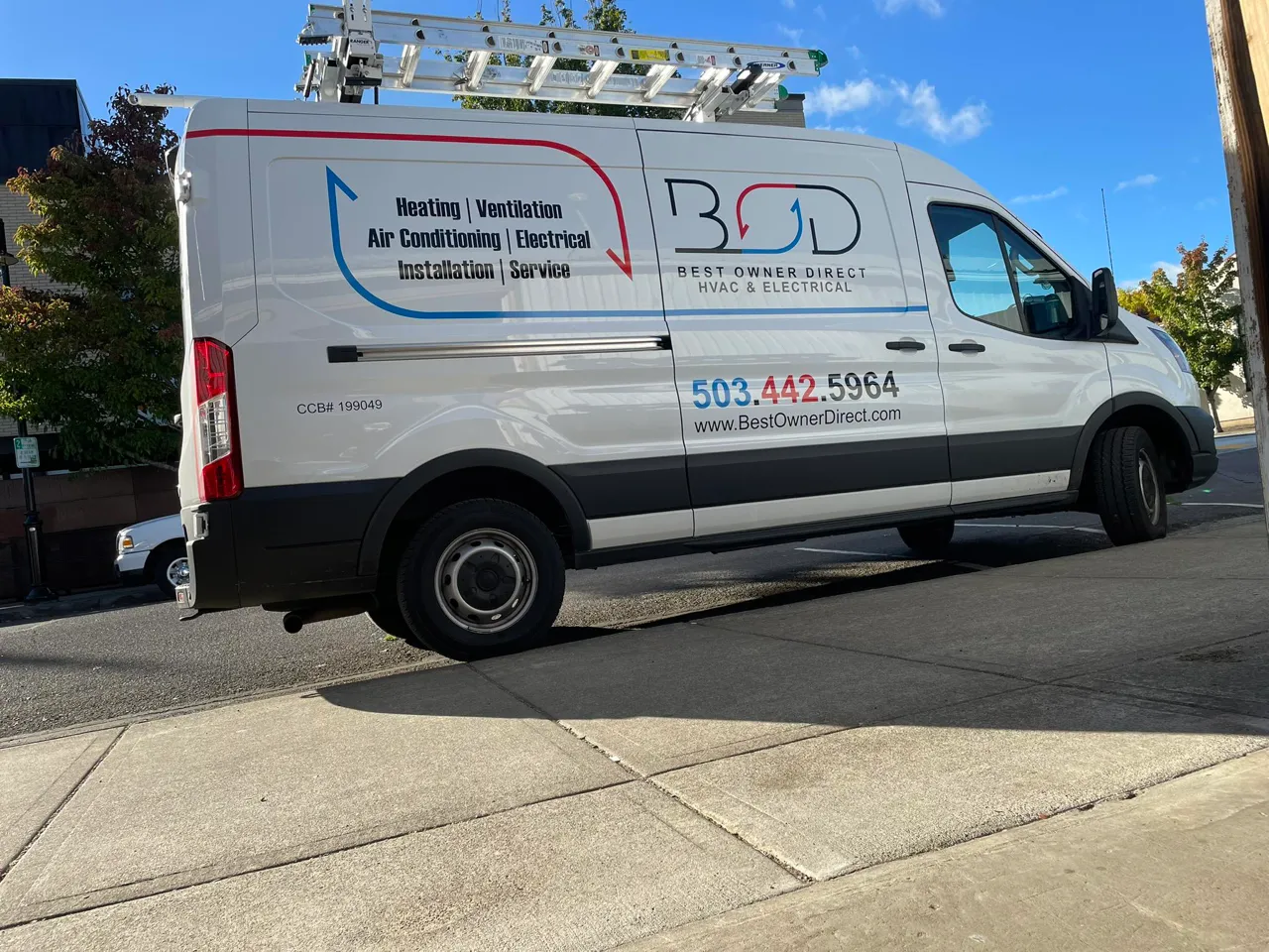 Best Owner Direct white van parked on the side of the road.