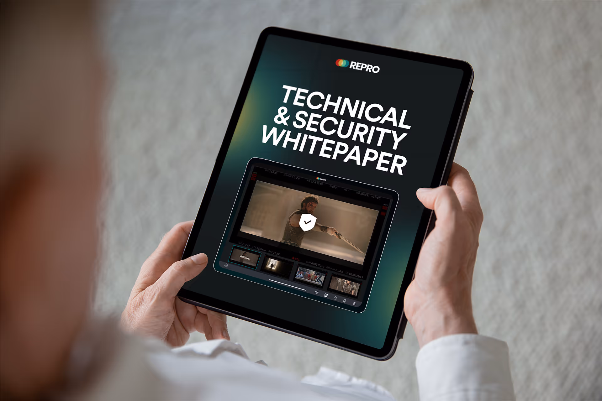 A man holding a tablet with a video playing on the screen.