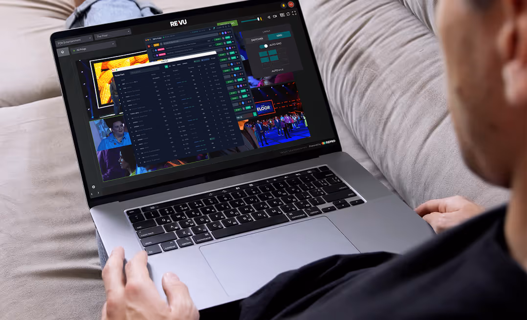 A person on a sofa monitoring multiple live camera feeds in RePro on a laptop.