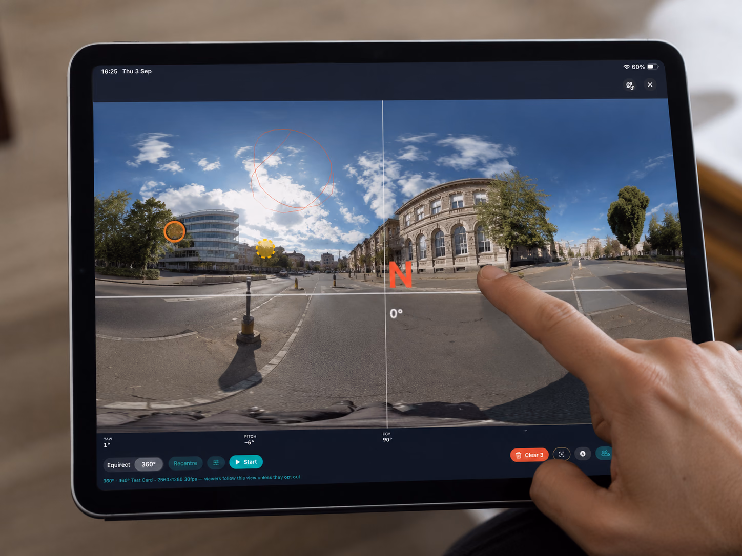 A finger on an iPad framing a 360-degree street view in Pulsar Mobile, with a north indicator overlaid.