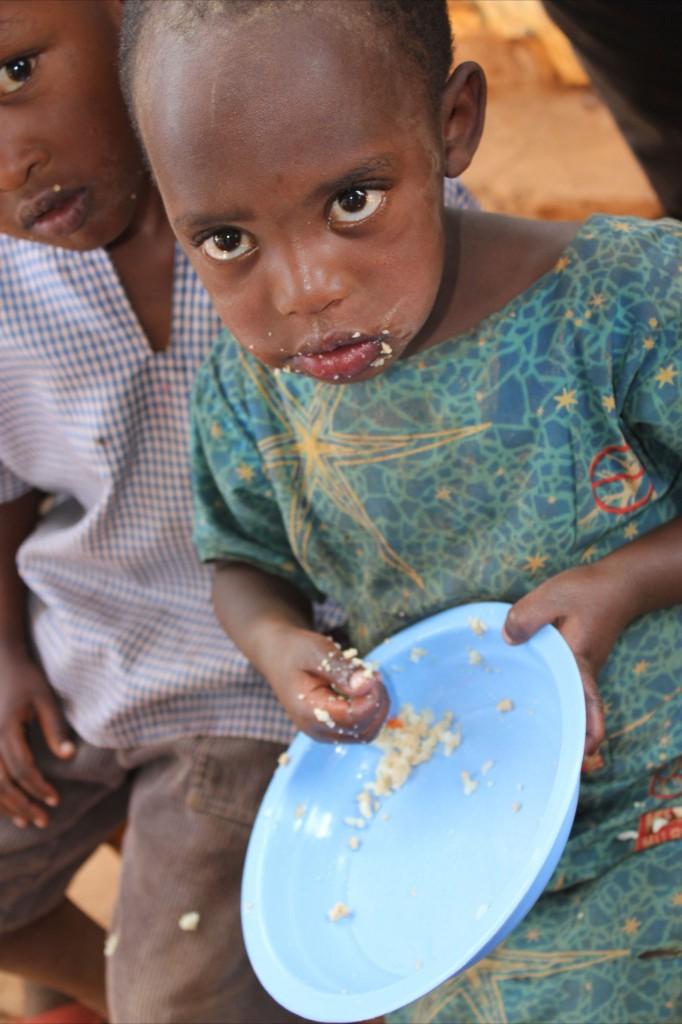 A child eating from a blue plateAI-generated content may be incorrect.