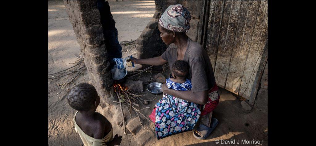 A person and child sitting outside by a fireAI-generated content may be incorrect.