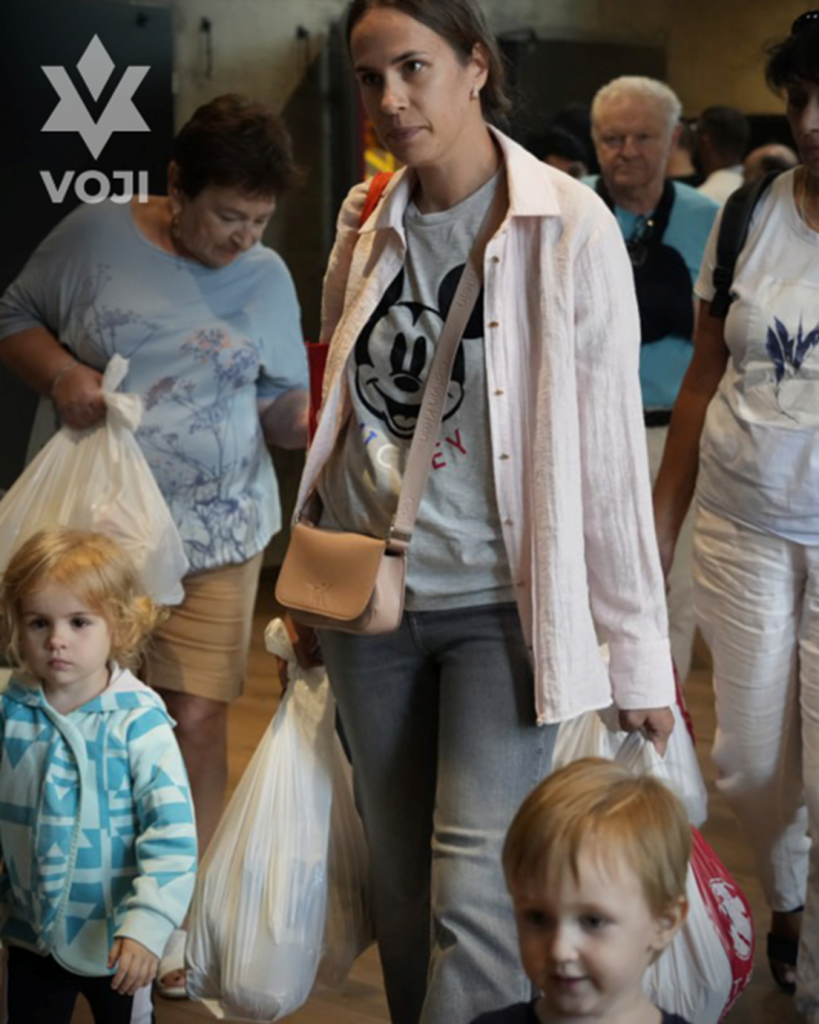 A person carrying bags and a childAI-generated content may be incorrect.