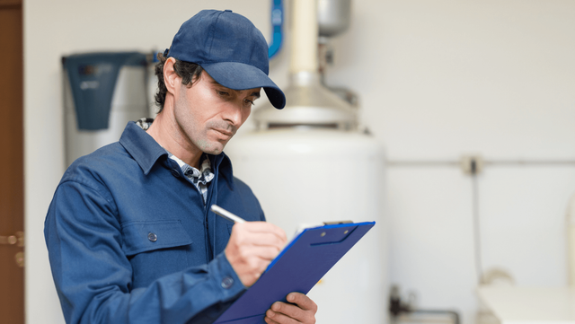 A man checking writing on a clipboard.