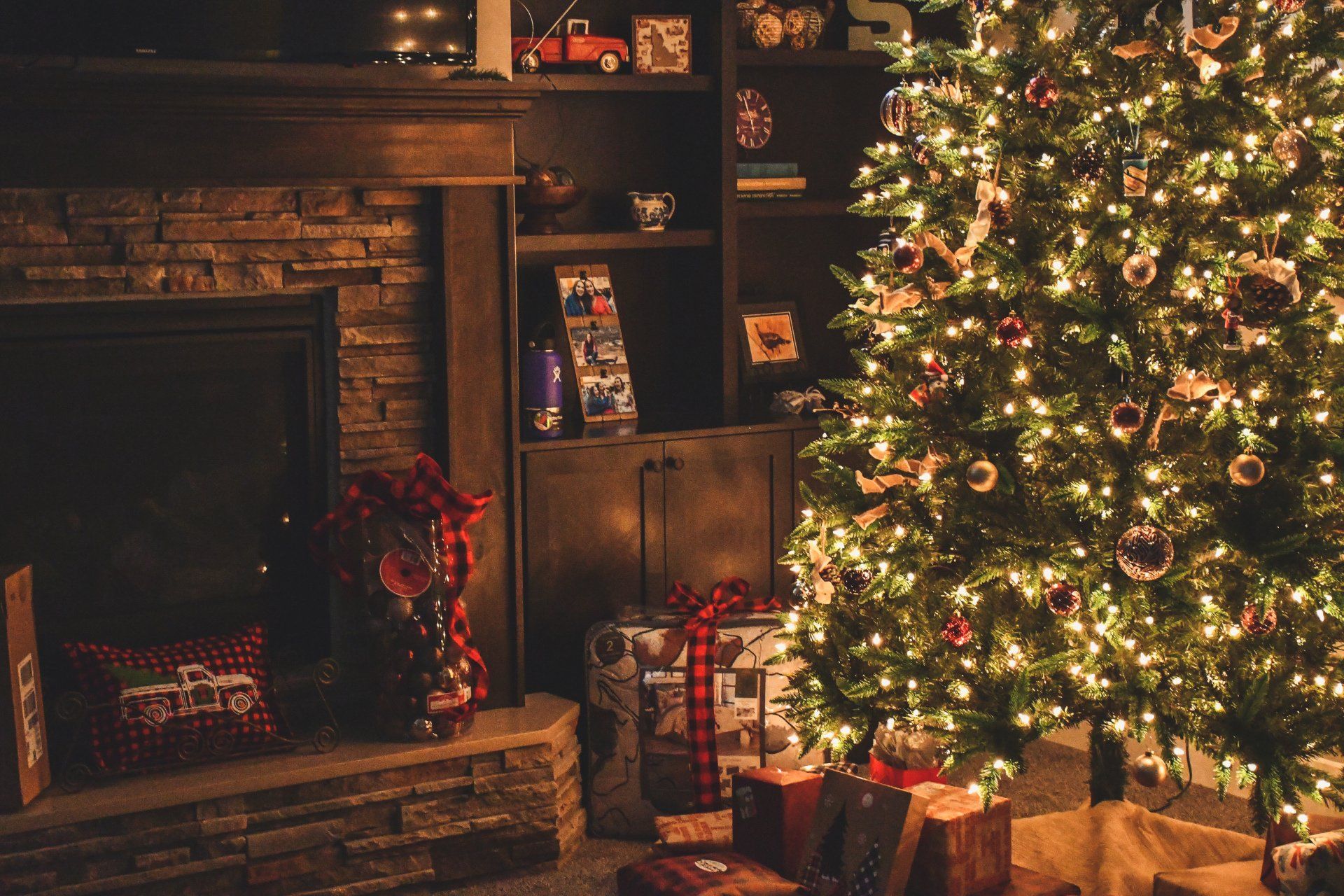 Cozy living room with a decorated Christmas tree, glowing lights, and wrapped gifts, highlighting potential indoor air quality issues during the holiday season.