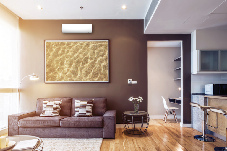 Ductless heat pump system mounted above a modern sofa in a stylish living room, showcasing energy-efficient heating solution for home comfort.