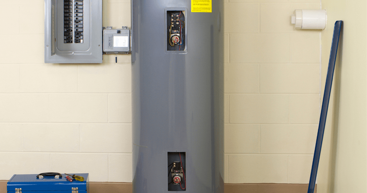 Heat pump water heater with visible electrical panel and tools, illustrating HVAC installation and maintenance services.