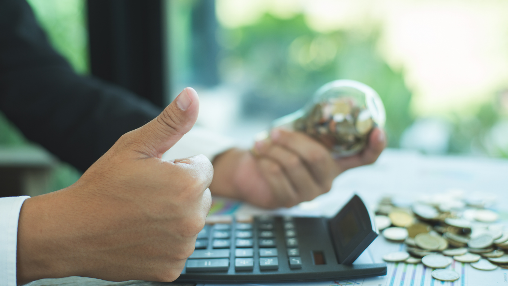 Person giving thumbs up while holding a jar of coins and using a calculator, symbolizing savings and financial benefits related to HVAC maintenance.