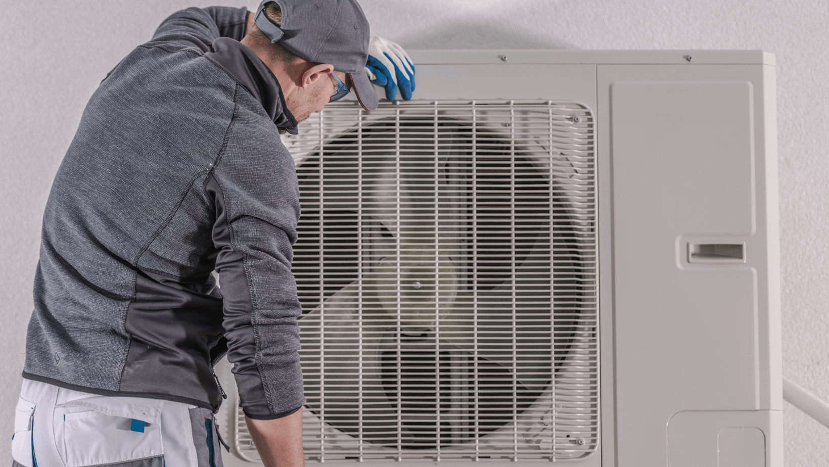 Technician servicing a ductless mini-split heat pump, emphasizing HVAC maintenance and installation services.